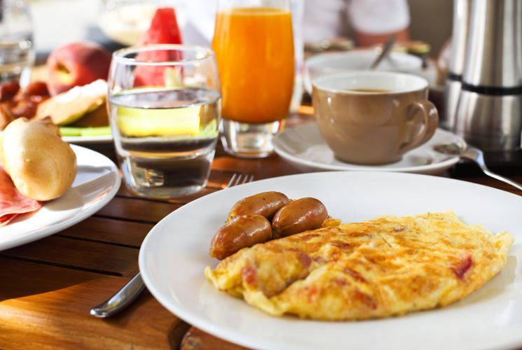 Tasty breakfast in the morning with omelet and sausages