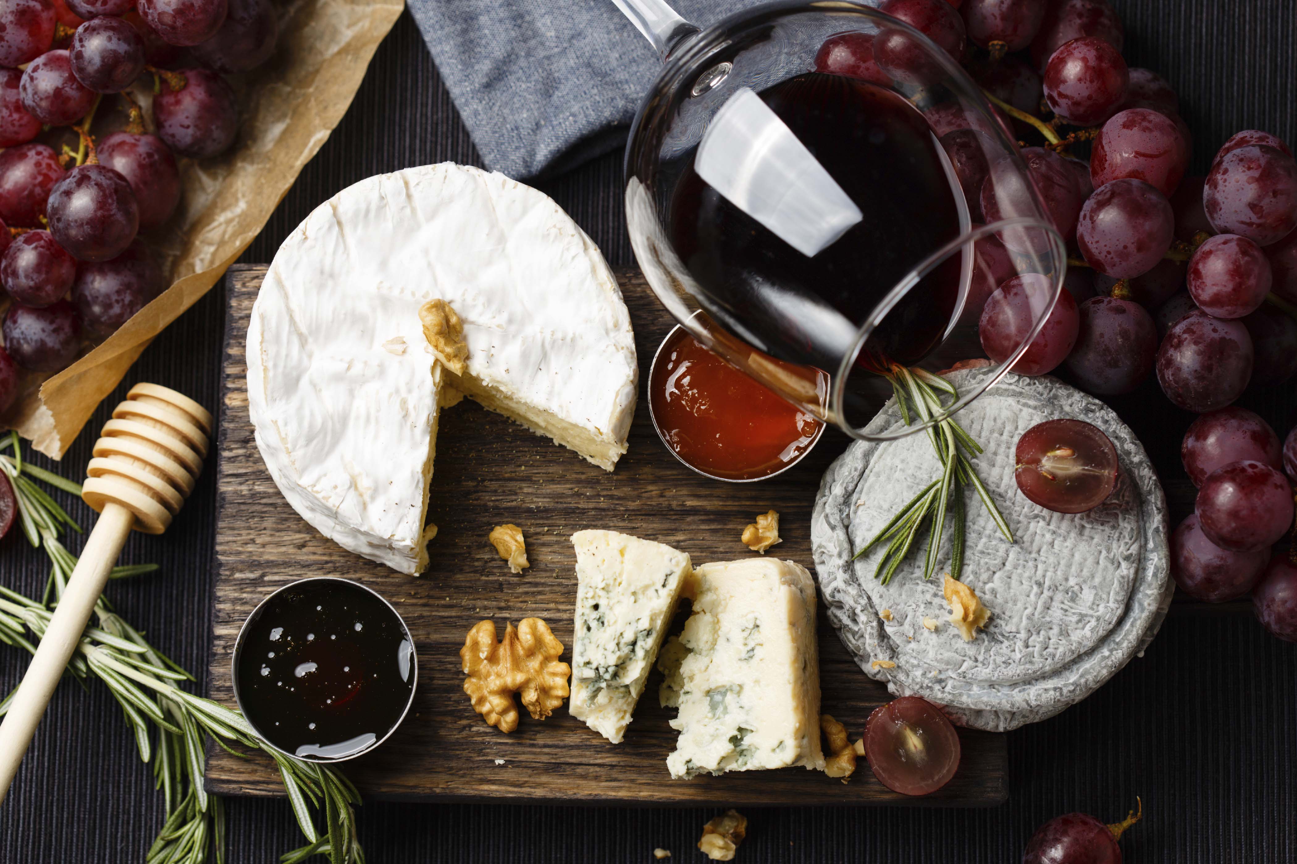 Cheese plate served with wine, jam and honey top view